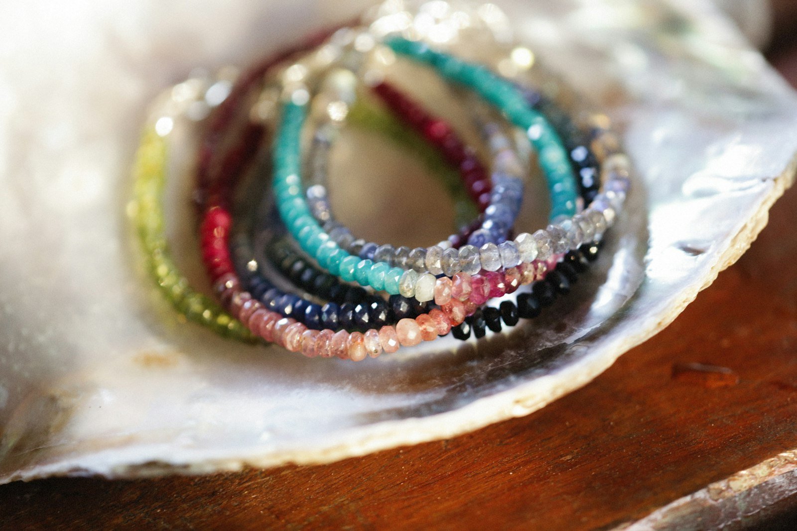 Beaded bracelet stack resting in an oyster shell